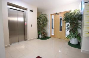 einen Büroflur mit Topfpflanzen und einen Aufzug in der Unterkunft Fantastic sea view apartment! in Portstewart + 7 Fotos