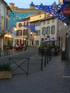 a person walking down a street with a kite at Hotel Du Pont Vieux in Carcassonne