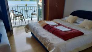 a bed in a room with a view of a balcony at Apartments Savić in Neum