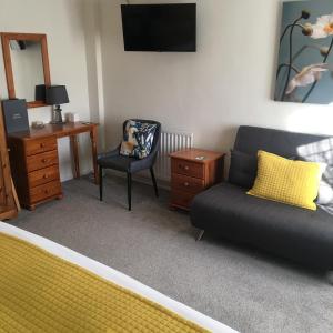 a living room with a couch and a desk and a chair at Spurwing Guest House in Wareham