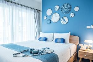 a bedroom with a blue wall with clocks on the wall at DeeProm Pattaya Hotel in Pattaya +119 photos