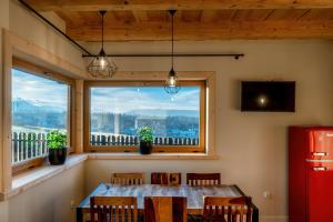 a dining room with a table and a window at DOMEK W UBOCY z widokiem na Giewont "Jacuzzi i Sauna w ofercie dodatkowo płatnej" in Murzasichle