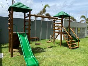 a playground with two swings and a slide at Beach Way Residence in Aquiraz
