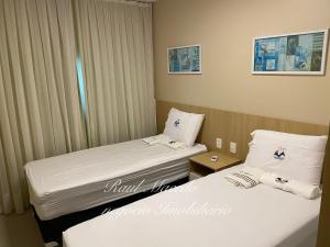 two beds in a hotel room with white sheets at Beach Way Residence in Aquiraz +18 photos