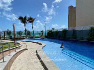 a man in a swimming pool at a resort at Beach Way Residence in Aquiraz