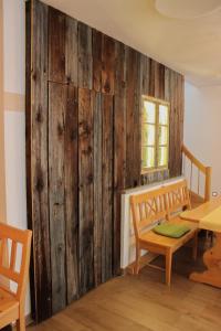 Habitación con pared de madera, mesa y sillas. en Wirtsberg Pension & Cafe 