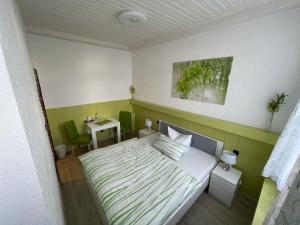 a small bedroom with a bed and a table at Hotel Schwanenburg in Kleve