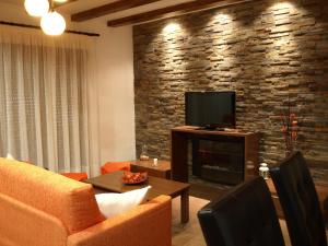 a living room with a fireplace and a television at Apartamentos Rurales El Palomar in Villar del Humo
