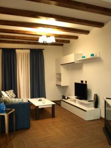 a living room with a couch and a tv at Apartamentos Rurales El Palomar in Villar del Humo