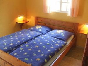 1 Schlafzimmer mit 2 Betten mit blauer Bettwäsche und einem Fenster in der Unterkunft Bungalows & Apartamentos Morani in Puerto Naos