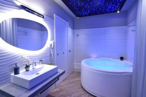 bagno con vasca, lavandino e specchio di Starry Sky Charming House ad Alghero