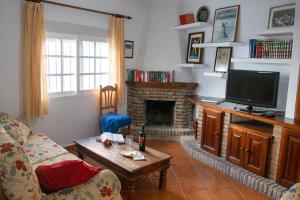 een woonkamer met een tv en een open haard bij Conil town house with roof terrace and great views, Baluarte in Conil de la Frontera