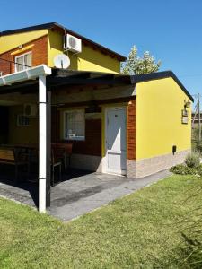 Victorica的住宿－Cabañas bajos medanales，黄色的房子,设有门和庭院