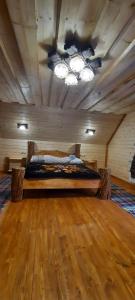 Bett in einem Zimmer mit Holzdecke in der Unterkunft Студіо Номер 5 Садиба У Ані in Synewyrska Poljana