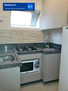 cocina con fregadero y microondas en Lindo apartamento Avenida Brasil, en Balneário Camboriú