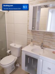 y baño con aseo, lavabo y espejo. en Lindo apartamento Avenida Brasil, en Balneário Camboriú