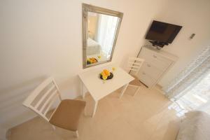 una mesa y sillas blancas en una habitación con espejo en Apartments Cale, en Orebić