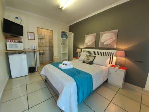 a bedroom with a large bed and a kitchen at Tehillah Guesthouse in Upington