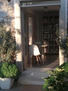 an open door to a patio with a white chair at Speires suites in Irakleia