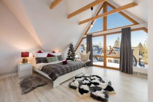 a bedroom with a bed and a large window at Bory6a Apartamenty in Zakopane