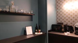 Habitación con encimera, microondas y botellas de vino. en MiHotel Bellecour en Lyon