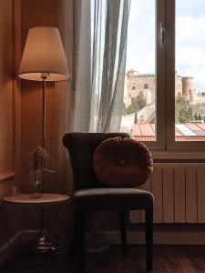 a chair and a lamp in a room with a window at Insula Barataria in Belmonte