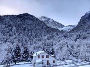 a house in front of a snow covered mountain at Hotel O Chiroulet in Bagnères-de-Bigorre