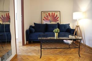 Classic apartments Pilsudskiego street في كراكوف: غرفة معيشة مع أريكة زرقاء وطاولة زجاجية