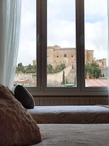 a bedroom with a window with a view of a castle at Insula Barataria in Belmonte