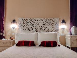 a bedroom with a white bed with two red pillows at Insula Barataria in Belmonte