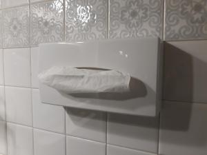 a white toilet in a white tiled wall at Hôtel Ambroise in Uzerche
