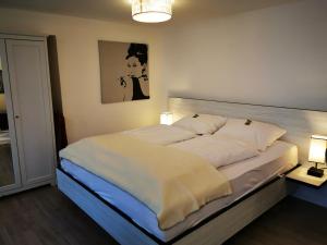 ein großes Bett in einem Zimmer mit zwei Lampen in der Unterkunft Haus Bolay in Oberstdorf