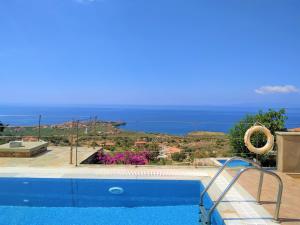 een zwembad met uitzicht op de oceaan bij ORATO VILLAGE in Pyrgos