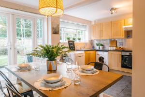 a kitchen with a wooden table and a dining room at Castle Gate by Spa Town Property - Central Location with Large Living Space in Warwick