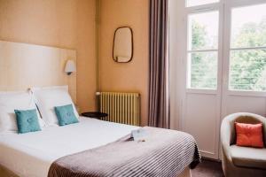 una camera d'albergo con letto e finestra di L'Hôtel Particulier Ascott a Saint Malo