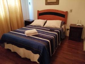 1 dormitorio con 1 cama con manta azul y blanca en America Departamentos, en Santiago