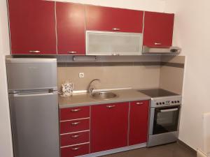 una piccola cucina con armadi rossi e lavandino di Amore@Tivat a Tivat