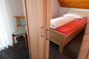 a small bedroom with a bed and a chair at Ferienwohnung im Steinachtal in Nagold