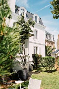 una casa bianca con sedie in cortile di L'Hôtel Particulier Ascott a Saint Malo