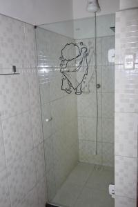 a bathroom with a shower with a monkey painted on the wall at Hey, Brothers! in Saquarema