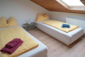 2 Betten in einem kleinen Zimmer mit Fenster in der Unterkunft Linz LIVIA in Linz