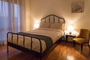 - une chambre avec un lit, une chaise et deux lampes dans l'établissement Casa del Carmine, à Anghiari