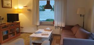 sala de estar con sofá, mesa y ventana en Vakantiewoning - B&B 'la bienvenue' in Venlo, Limburg, en Venlo