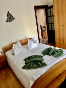 Una cama con toallas verdes encima. en Apartament Confort - Baile Olanesti en Băile Olăneşti