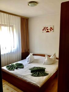 a bedroom with a bed with green towels on it at Apartament Confort - Baile Olanesti in Băile Olăneşti