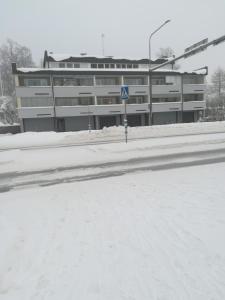 a snow covered street in front of a building at Koskentien yksiö in Jämsä