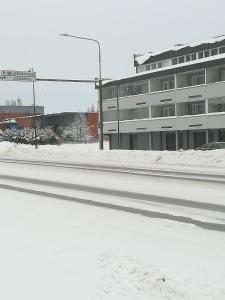 uma rua vazia em frente a um edifício na neve em Koskentien yksiö em Jämsä