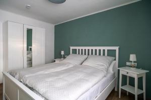 1 dormitorio con cama blanca y paredes verdes en Bio Weinhaus Krauss Zellertal, en Zellertal