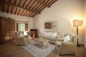 un soggiorno con 2 sedie, un divano e un tavolo di Torre di Badia a Badia A Passignano