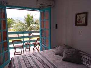 Schlafzimmer mit einem Bett und Blick auf einen Balkon in der Unterkunft Pousada Gaucha Caiobá in Matinhos